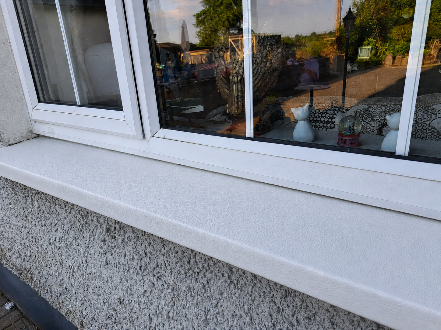 Image of Decomin Quartz primer painted onto a concrete window sill in preparation for a Decosill application